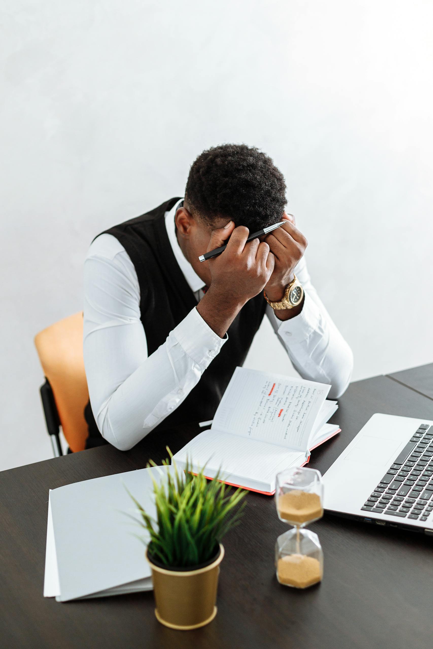 Resources 7 a businessman overwhelmed working indoors with a notebook laptop and hourglass. 5060985 scaled 1